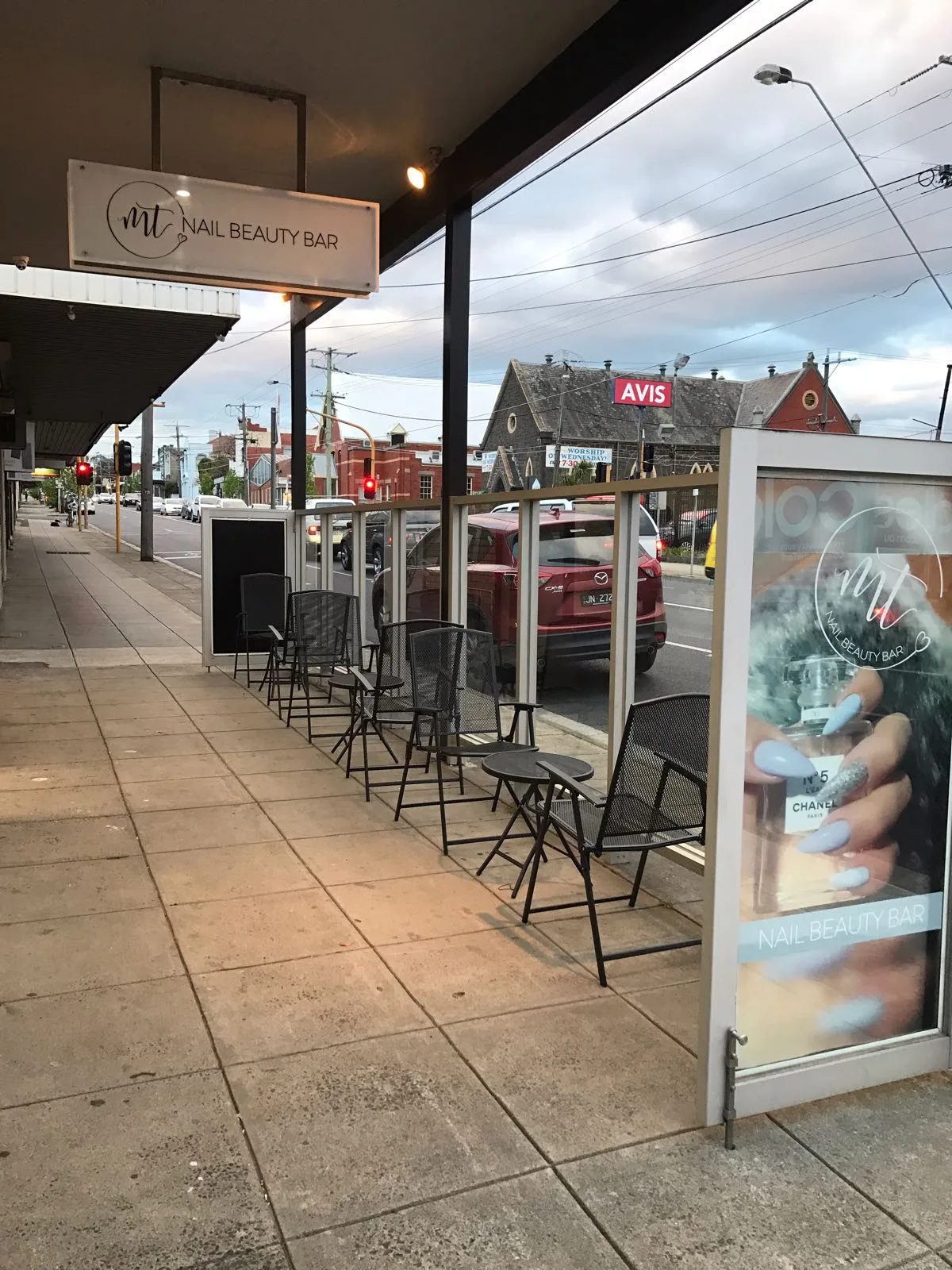 MT Nail Beauty Bar shopfront on High Street, Preston — awning sign, outdoor seating area, tram-lined street