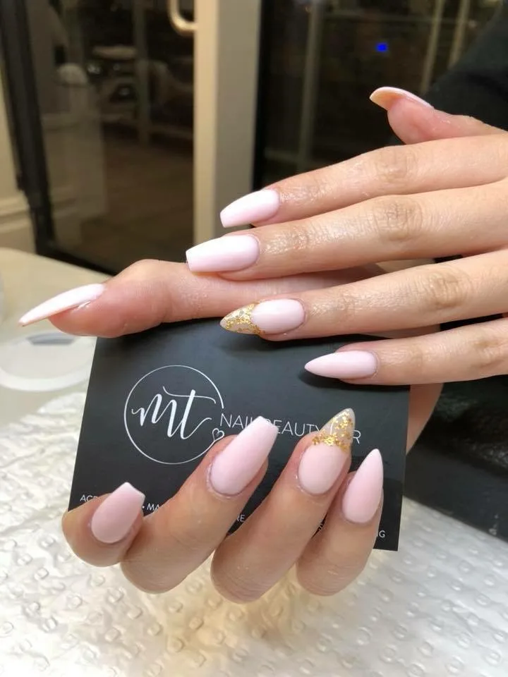 Soft-pink almond nails with gold-flecked accents