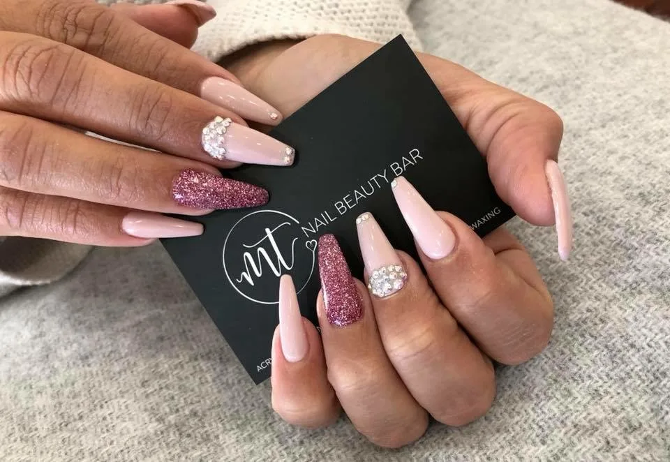 Nude and pink-glitter coffin nails with crystal accents